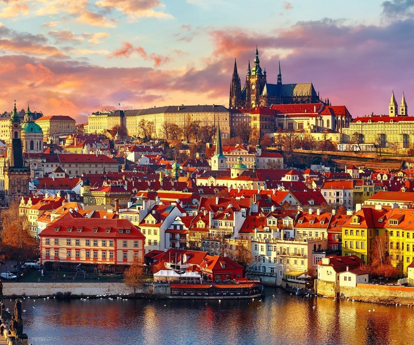 Panoramic view above at Charles Bridge Prague Castle and river Vltava Prague Czech Republic. Picturesque landscape with sunset old town houses with red tegular roofs and broach tower.